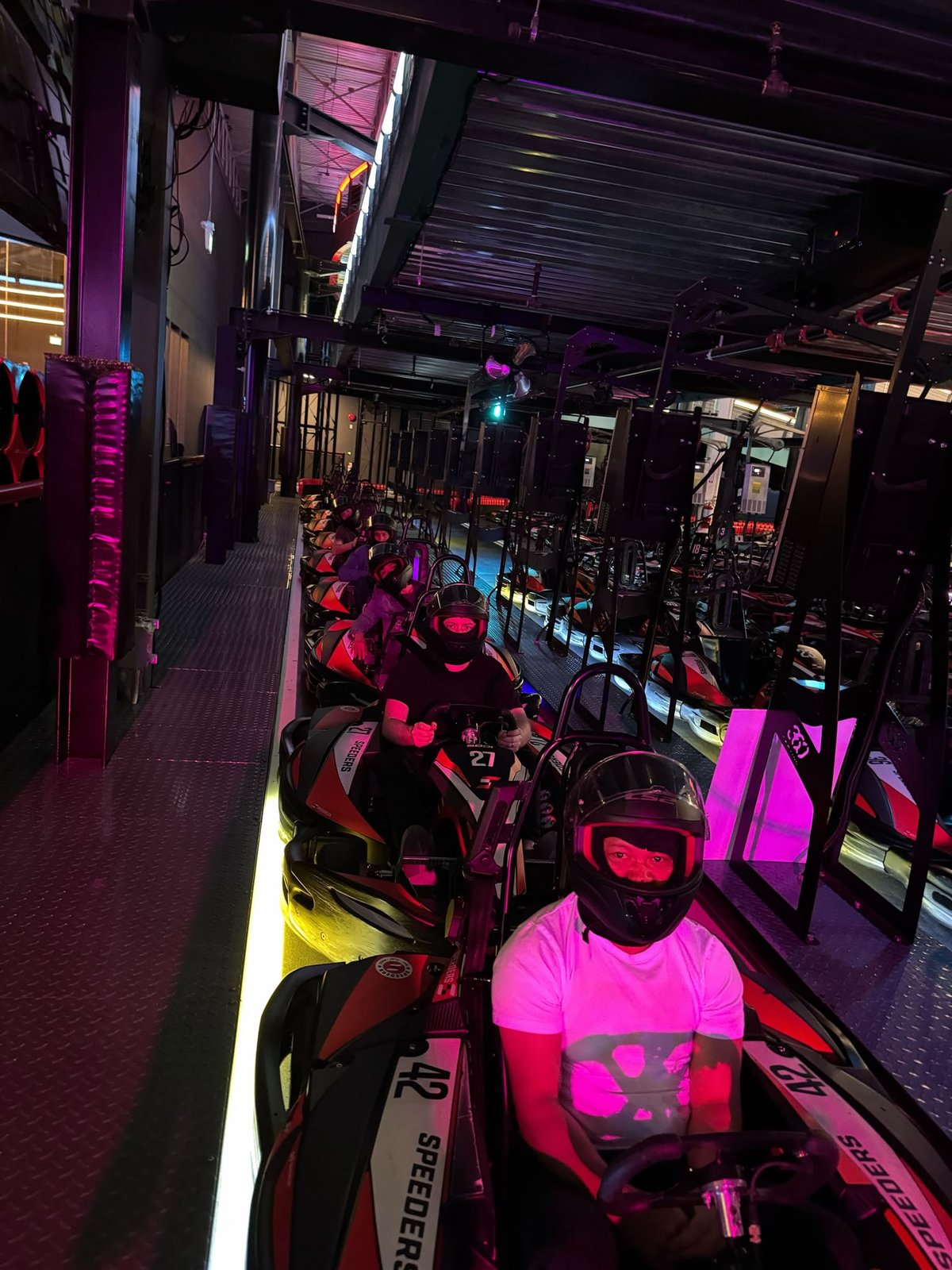 The OverSushi team in helmets at a go-kart track.